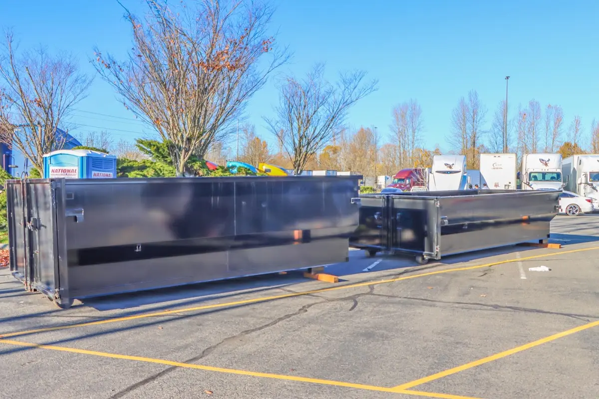 Professional dumpster rental service with roll-off container on residential driveway in Pueblo West